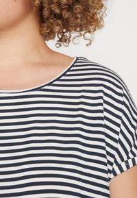 Camiseta de rayas navy y blancas con cuello redondo y mangas cortas. Fabricada con tela suave de textura lisa y un corte informal.