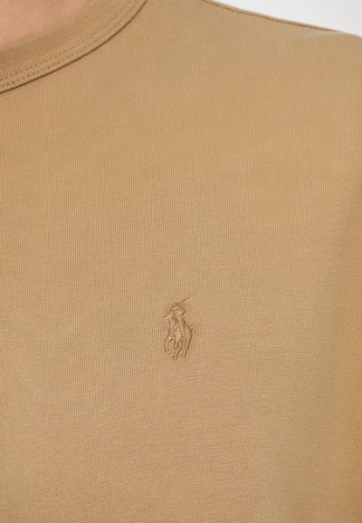 Svieši īsām piedurknēm T-krekls ar ribotu tekstūru un mazu, izšūtu zirga un jātnieka logo kreisajā krūtī.