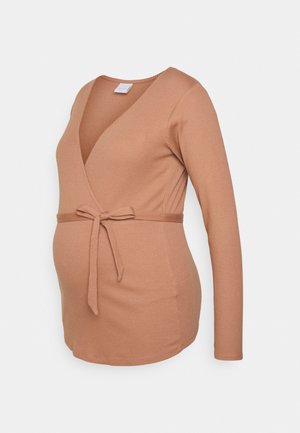 Camisola de manga longa em tecido ribado macio, com um decote em V profundo, um laço na cintura e um design justo numa cor bege quente.