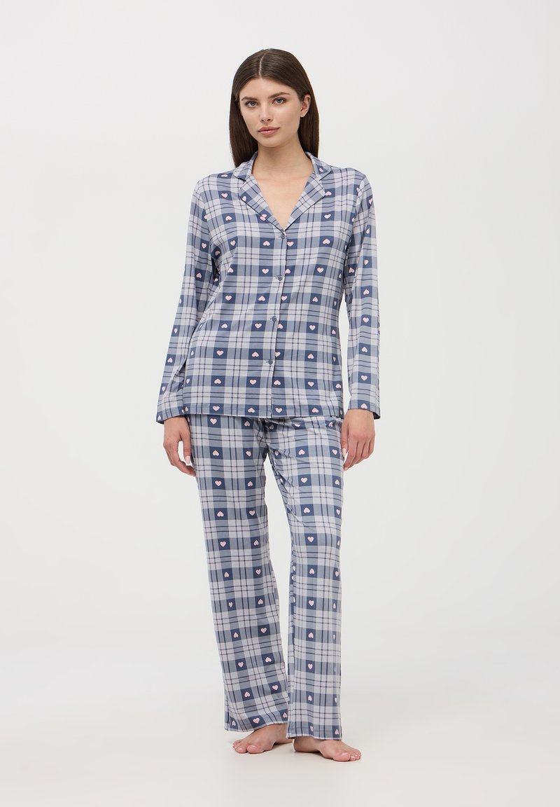 Pigiami a quadri blu e bianchi con accenti rosa a forma di cuore, composti da una camicia con bottoni e pantaloni lunghi, realizzati in un tessuto leggero.