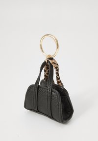 Black faux leather mini handbag with two handles, featuring a leopard print accent and a gold keyring. Textured surface and structured shape.