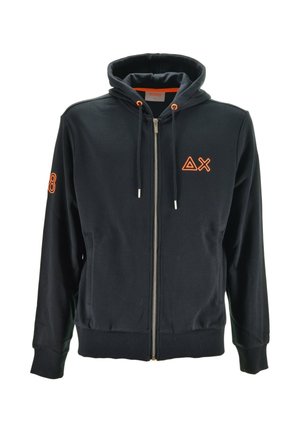 Felpa nera con zip, con asole per il laccio arancione, triangolo arancione e logo a forma di X sul petto sinistro, e numero 8 sulla manica destra.