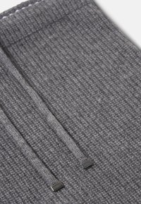 Gray knitted scarf with a ribbed texture, featuring two fabric strings and metal accents at the ends. Soft, warm material.
