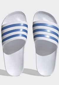 Infradito bianchi con tre strisce blu lucide sulla fascia. Parte superiore texturizzata e suola liscia. Design aperto con punta e tallone.