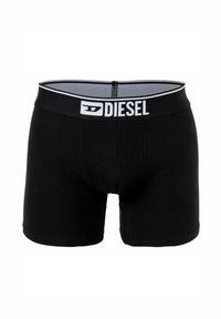 Boxer in cotone nero morbido, con un logo "DIESEL" bianco a contrasto sulla cintura elastica. Texture liscia, design aderente.