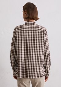 Brown and cream checked shirt with a collar, long sleeves, and buttons. Made from lightweight fabric with a relaxed fit and back yoke detail.