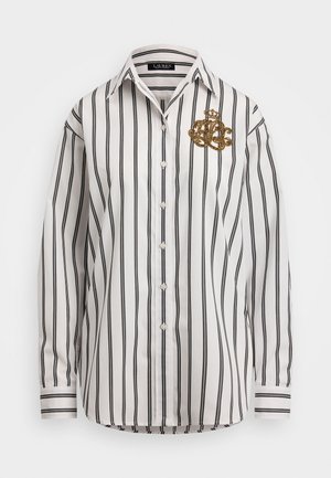 Weißes Langarmhemd mit schwarzen vertikalen Streifen, mit einem goldenen gestickten Wappen auf der linken Brust und Knopfleiste.