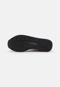 Suela de zapato de goma negra con agarre texturizado, que presenta patrones moldeados y un logo central. Punta ligeramente redondeada para mayor confort.