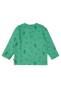 Maglietta verde a maniche lunghe in morbido cotone, con una stampa nera di animali e natura che include scoiattoli, ricci e foglie.