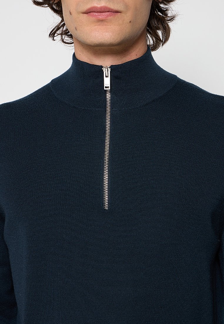 Marineblauwe gebreide sweatshirt met een hoge kraag en een zilveren rits. Kenmerkt zich door een gestructureerde stof en een getailleerd ontwerp.