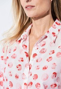 Witte blouse met roze aquarelvlekken, met opstaande kraag en zachte textuur, met een moderne pasvorm en casual ontwerp.