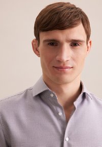 Button-up Hemd in einem lila und weißen texturierten Muster, mit klassischem Kragen und frontaler Knopfleiste.