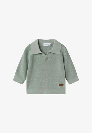 Maglione lavorato a maglia verde chiaro con ampio colletto e maniche a tre quarti. Presenta un'etichetta di accento marrone sul lato inferiore.