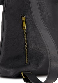 Schwarze Lederhandtasche mit strukturiertem Oberflächen, ausgestattet mit einem goldenen Metallreißverschluss und einem schwarzen Trageriemen. Der Reißverschluss befindet sich auf der Vorderseite.