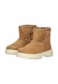 Bottines en daim marron avec zip sur le côté, semelle en caoutchouc blanche et couture décorative le long du haut. Design compact avec bout rond.