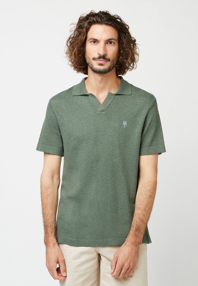Kurzarm-Polohemd in olivgrün, mit V-Ausschnitt, weichem Stoff und kleinem Baum-Logo auf der linken Brust.