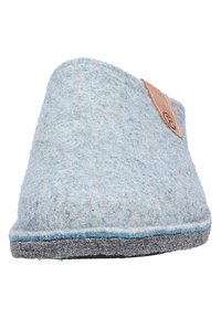 Pantofole in feltro blu con una parte superiore arrotondata, dettagli grigio chiaro e un'etichetta in pelle su un lato. La suola è scura e piatta.