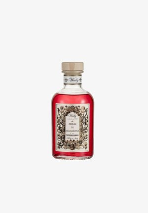 Bottiglia di vetro con liquido rosso etichettato "Arilli di Melagrana", prodotto profumato, etichetta decorativa stile vintage, tappo in legno, made in Italy.