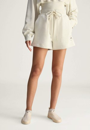 Light beige shorts with an elastic waistband and drawstring, featuring side pockets and a small logo on the left hem.