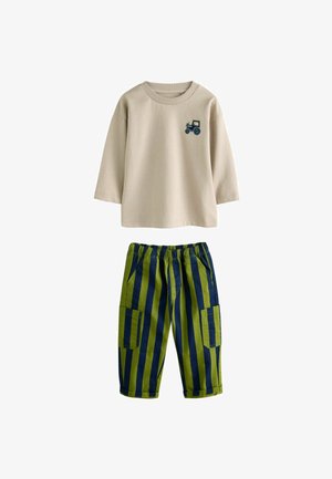 Šviesiai ruda ilgomis rankovėmis marškinėliai su traktoriaus siuvinėjimu; žali vandenyniniai dryžuoti kelnės su kišenėmis ir elastinga juosmens juosta.