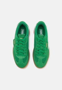 Gröna sportskor med ovandel i mesh och detaljer i mocka, med vita detaljer, runda snören och en brun gummisula.