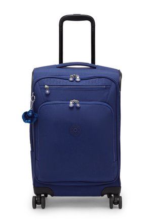 Valigia verticale morbida blu con quattro ruote, manico estensibile nero, tasche anteriori con cerniera e un piccolo portachiavi in peluche sul lato.