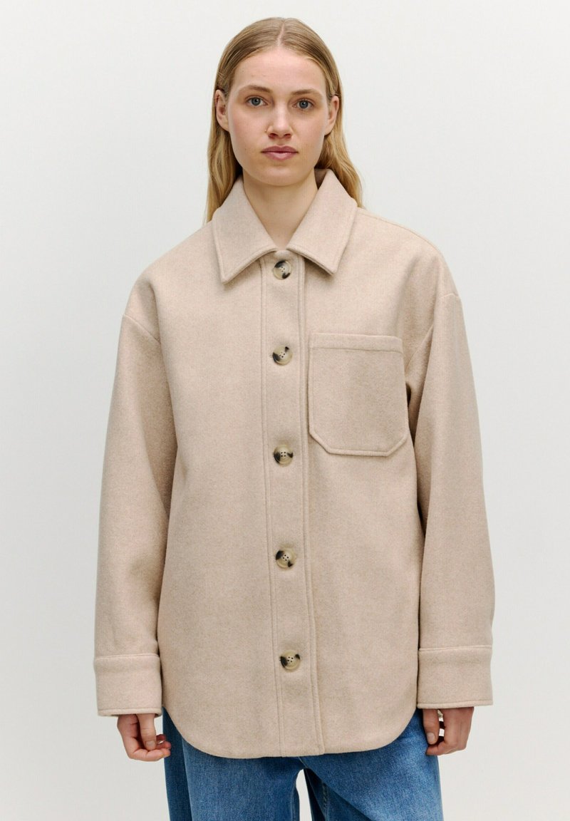 Beige Wollmischung Hemdjacke mit Spread-Kragen, Fronttasche und großen Knöpfen. Lockere Passform mit langen Ärmeln und umgeschlagenen Säumen.