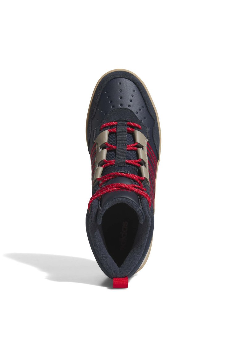 Marinblå og rød atletiksko med tekstureret overflade, røde snørrebånd, sølv øjer og en beige gummisål. Har perforeringer på tåpartiet.