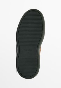 Chaussure en suede marron avec une semelle en caoutchouc noir, présentant des rainures horizontales pour l'adhérence et un détail de logo en relief. Taille 42.