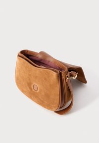 Bruine suède en lederen crossbodytas met gouden gesp, open klep en zichtbare donkerroze stoffen voering aan de binnenkant.