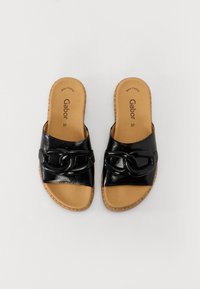 Des sandales noires à glissière en cuir brillant avec un design de brides tressées et une semelle intérieure texturée couleur tan. Légères avec une semelle extérieure semblable à du liège.