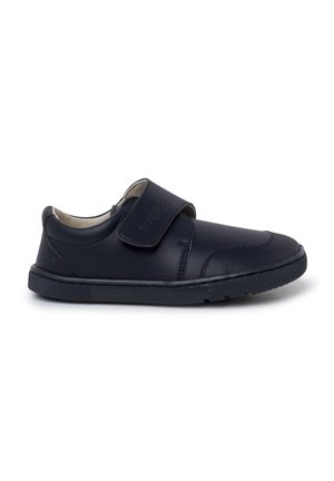 Chaussure pour enfant en cuir noir avec un talon rembourré, un embout arrondi, une semelle en caoutchouc texturé et une fermeture à bande velcro ajustable sur fond blanc.