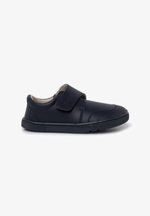 Chaussure pour enfant en cuir noir avec un talon rembourré, un embout arrondi, une semelle en caoutchouc texturé et une fermeture à bande velcro ajustable sur fond blanc.