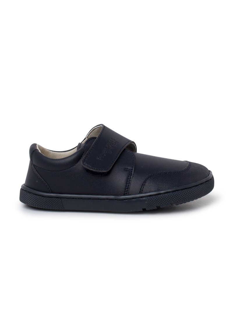 Chaussure pour enfant en cuir noir avec un talon rembourré, un embout arrondi, une semelle en caoutchouc texturé et une fermeture à bande velcro ajustable sur fond blanc.