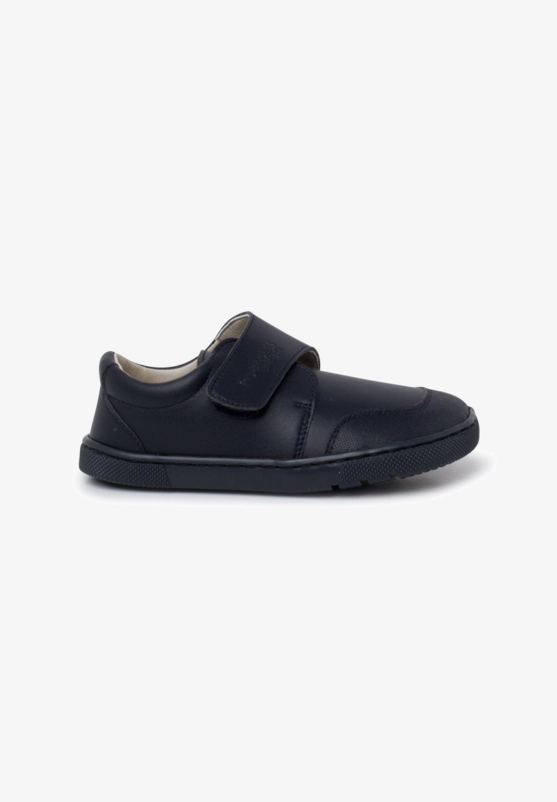Chaussure pour enfant en cuir noir avec un talon rembourré, un embout arrondi, une semelle en caoutchouc texturé et une fermeture à bande velcro ajustable sur fond blanc.