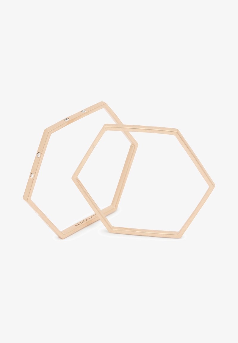 Deux bracelets ouverts en forme d’hexagone en or rose, dont l’un avec de petits cristaux incrustés, présentés sur fond blanc.