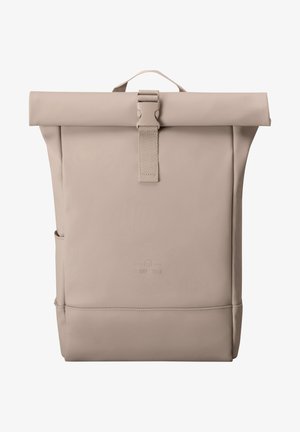 Beżowy plecak roll-top wykonany z wodoodpornego materiału, z przednim zapięciem na klamrę, kieszenią boczną oraz tłoczonym logo na dole.