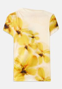 T-skjorte med korte ermer laget av et mykt stoff, med et uklar blomsterdesign i gule og kremfarger, med liten rynke på den ene siden.