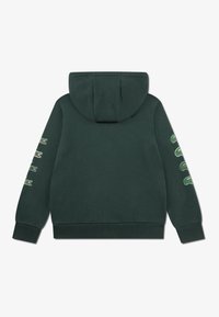 Hoodie verde-escuro com capuz, punhos e bainha canelados. Apresenta vários logótipos de crocodilo em verde na manga esquerda. Material de algodão.