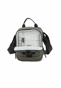Mochila verde oliva con un interior gris suave que presenta un patrón en contorno, compartimentos con cremallera y una correa para el hombro ajustable.