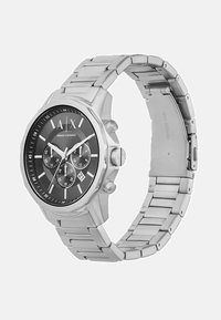 Roostevabast terasest nutikell musta kellaga, hõbedased aktsendid, kronograafi alad ja link-käevõru disain. Omab kuupäeva näidikut.