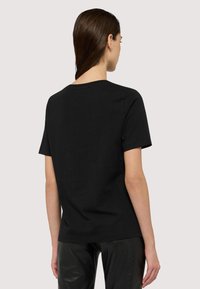 Czarna bawełniana koszulka z krótkim rękawem i okrągłym dekoltem, charakteryzująca się gładką fakturą oraz prostym wzornictwem bez widocznych wzorów czy akcentów.