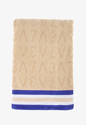 Asciugamano beige con numeri e lettere in rilievo, bordato con strisce blu, bianche e beige per un contrasto. Texture morbida.