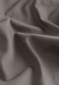 Woven fabric in dark gray with a smooth texture, exhibiting gentle draping and subtle sheen, highlighting fine stitching details.