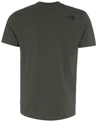 T-shirt vert foncé à manches courtes en coton. Présente un col rond et un petit logo noir sur le haut du dos. Texture douce.