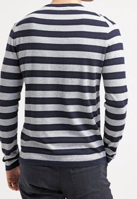 Marinblå och grårandig långärmad skjorta med rund halsringning och ribbade ärmslut, tillverkad av mjukt tyg, med kraftiga horisontella ränder.