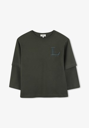 Donkergroene lange mouwen shirt met een ronde hals. Heeft een logo op de linkerborst in dezelfde kleur. Zachte, lichte katoenen stof.