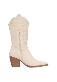 Botas de cowboy beige con costuras en zigzag, punta afilada y cremallera lateral. Cuentan con un tacón mediano apilado y material sintético suave.