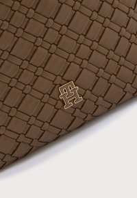 Geantă maro din piele împletită cu suprafață texturată și accent auriu cu logo, având o formă rectangulară și un design împletit.