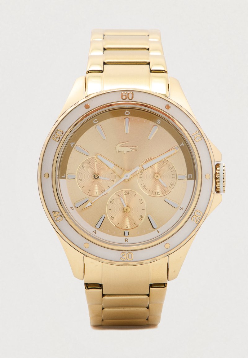 Zlaté kovové náramkové hodinky se třemi subčíselníky, indexovými hodinovými značkami a otočným rámečkem označeným po deseti minutách.